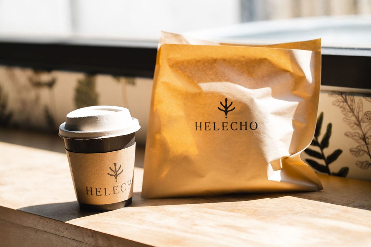 A Helecho cup and paper bag on a sunlit windowsill