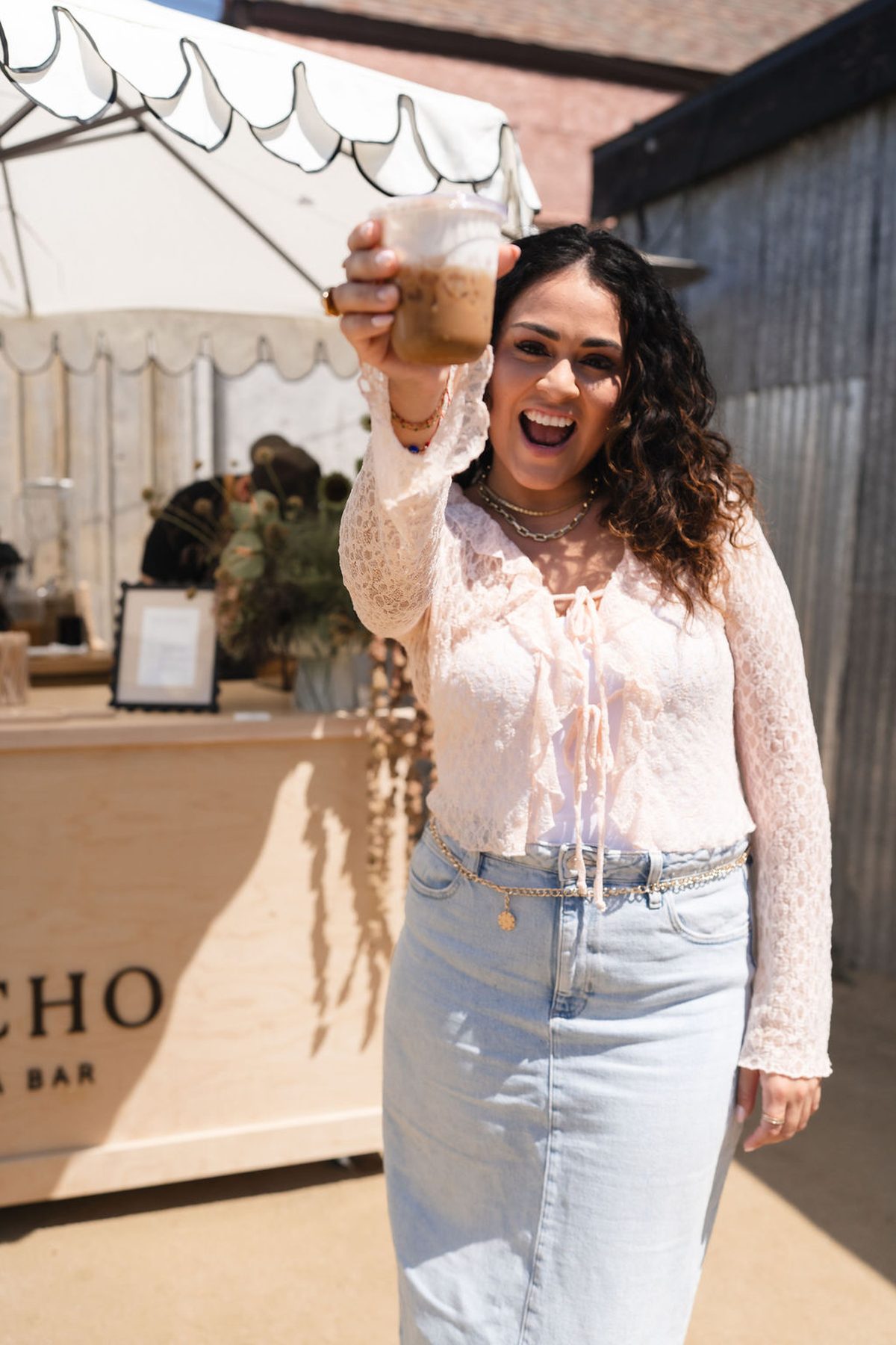 A guest holding up an iced coffee