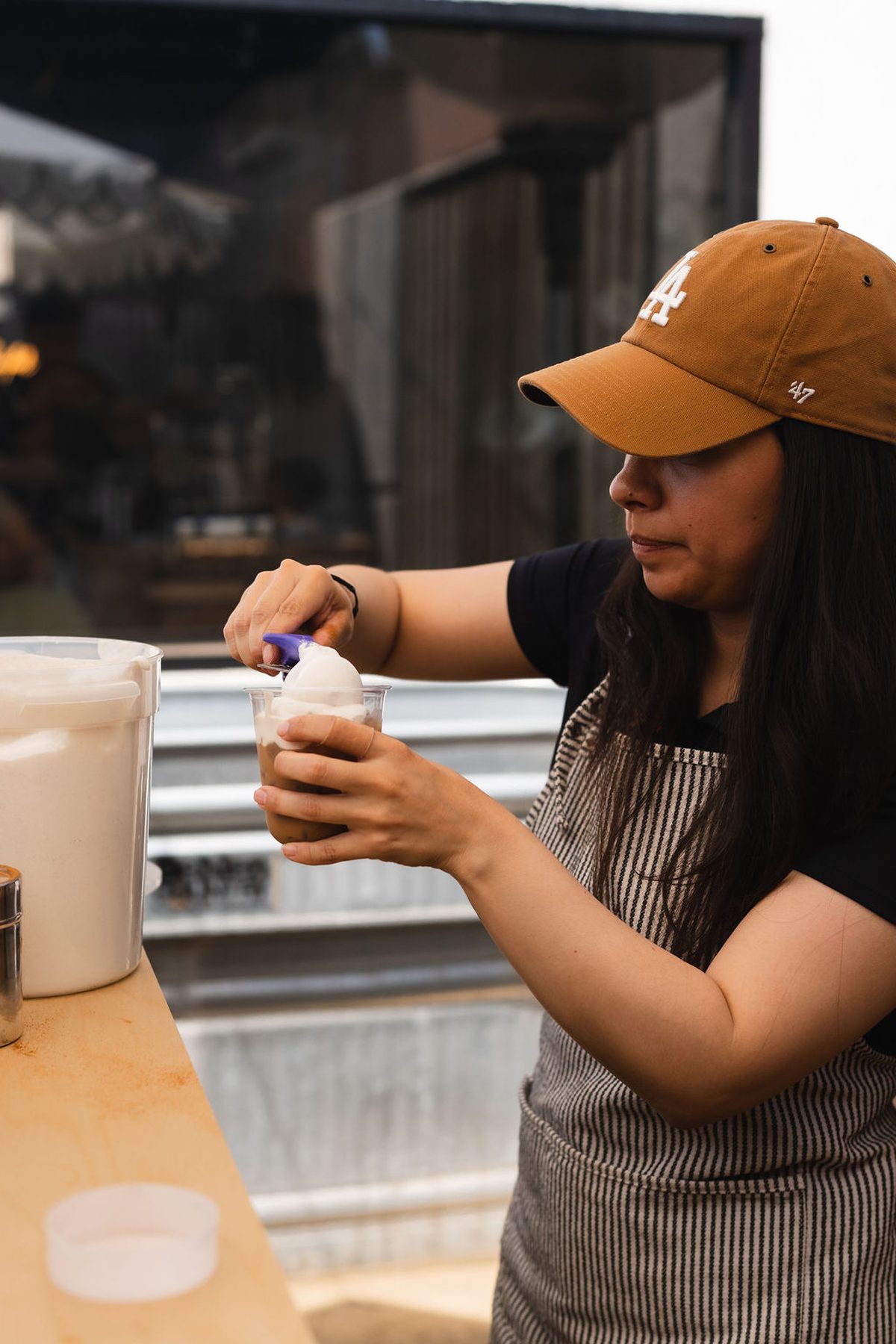 Cold foam going onto an iced coffee